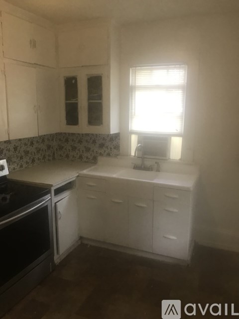 A kitchen with white cabinets and a black stove top oven.