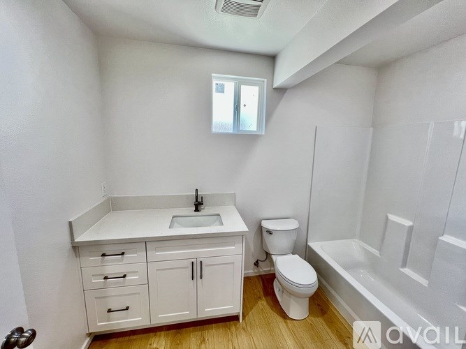 A small bathroom with a toilet, sink, and bathtub.