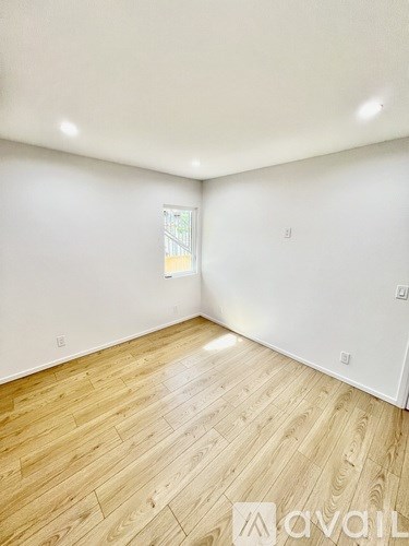 A room with wooden flooring and white walls.
