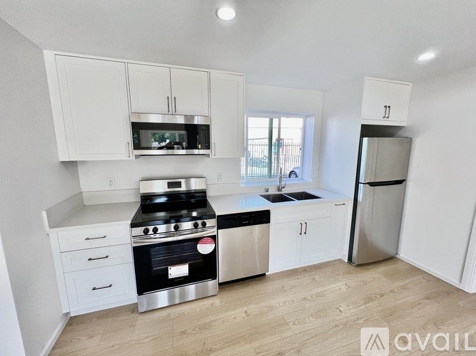 A kitchen with white cabinets and a stove top oven.