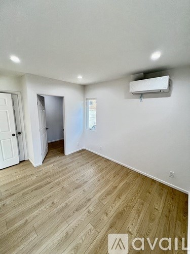 A room with wooden flooring and a window.