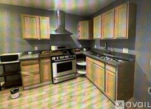 A kitchen with wooden cabinets and a black stove top oven.