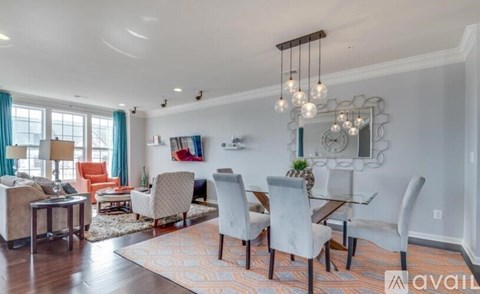 A living room with a large mirror on the wall and a dining table with chairs.