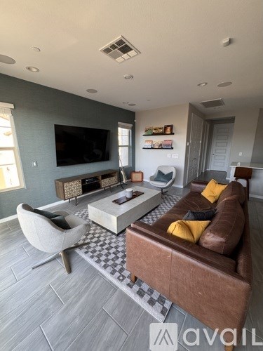 A living room with a brown couch and a television on the wall.