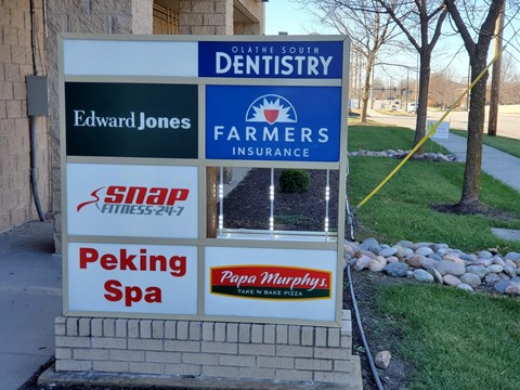 A sign for Edward Jones is on a signpost with other businesses.