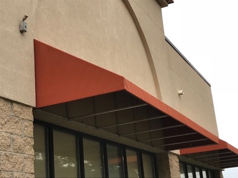 A building with a red awning over a window.