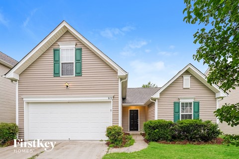 A two-story house with a garage and a driveway.