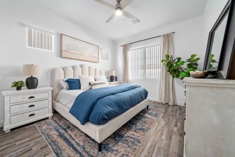 A bedroom with a large bed and a ceiling fan.