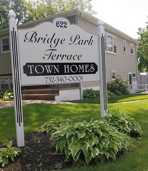 A sign for Bridge Park Terrace with a phone number on it.