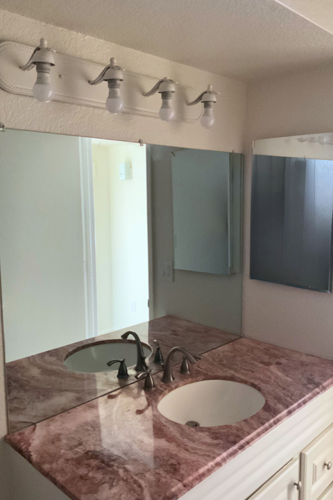 A bathroom with a marble countertop and a white sink.