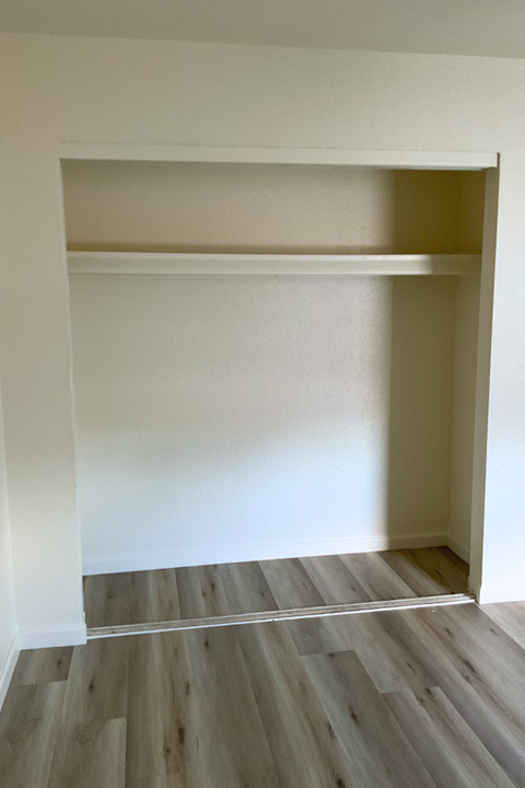 A room with a white wall and a wooden floor.