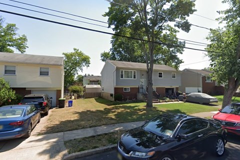 A black car is parked on the right side of a street.