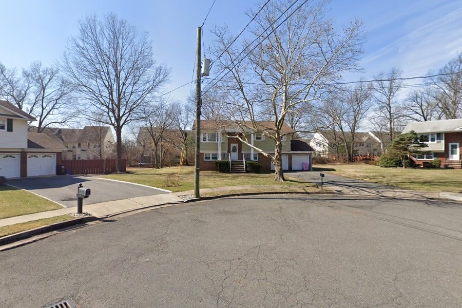A residential street with houses on both sides and a mailbox on the left.
