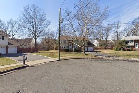 A residential street with houses on both sides and a mailbox on the left.