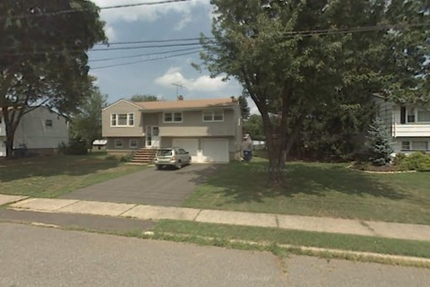 A house with a car parked in front.