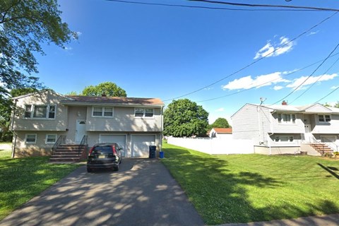 A house with a car parked in front of it.