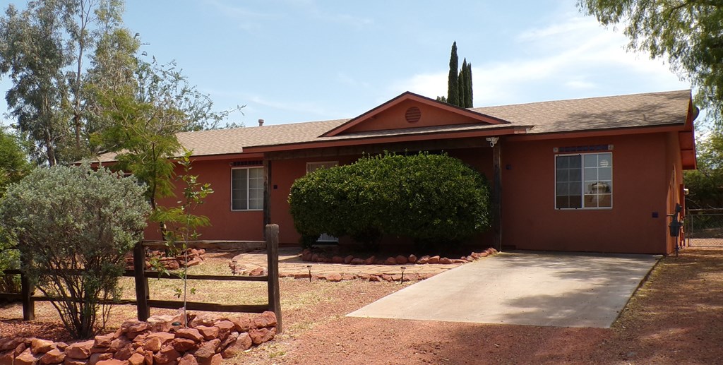 A house with a red roof and a brown fence.