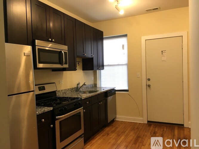 A kitchen with black cabinets and stainless steel appliances.