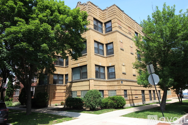 A brown building with a chevron design on the top floor.