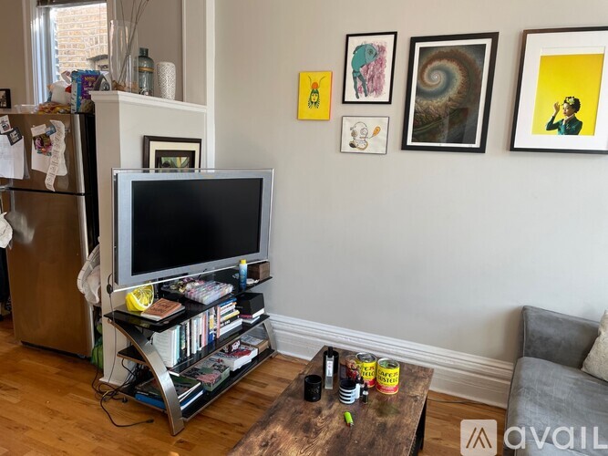 A living room with a television, a bookshelf, and a coffee table.