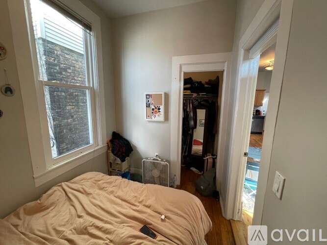 A bedroom with a bed, a window, and a closet.