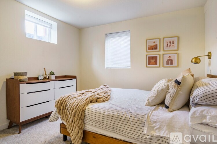 A bedroom with a bed, dresser, and window.