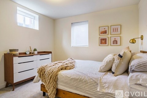 A bedroom with a bed, dresser, and window.