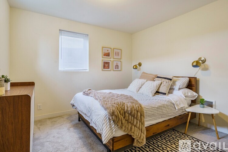 A bedroom with a bed, a nightstand, and a small table.