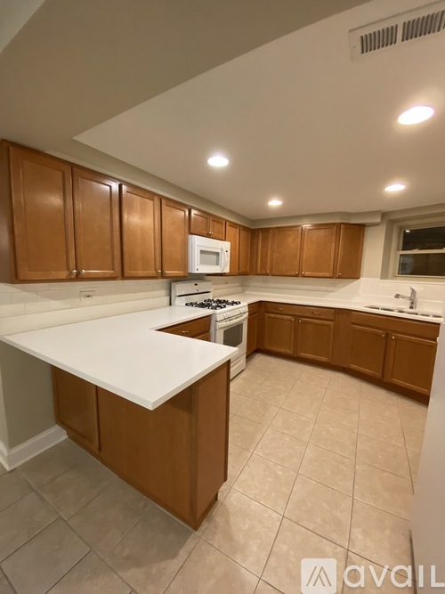 A kitchen with brown cabinets and white countertops.