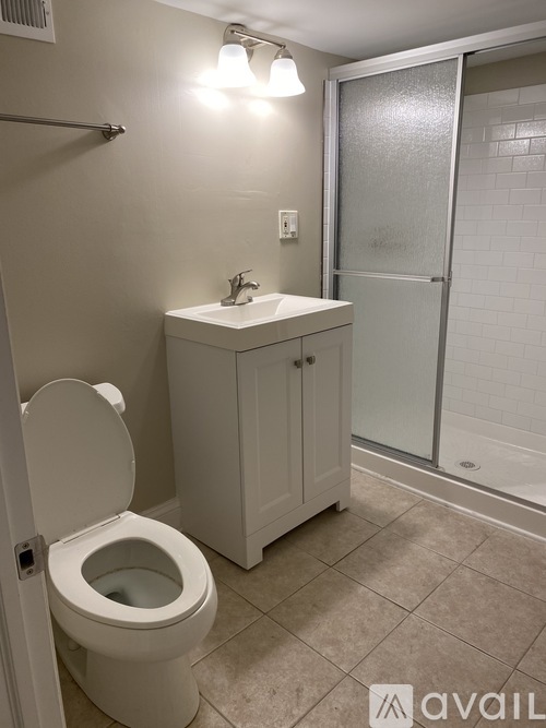 A bathroom with a toilet, sink, and shower.