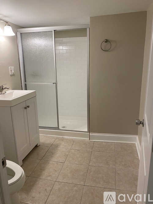 A bathroom with a toilet, sink, and shower.