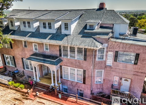 A pink house with a black roof and white trim.