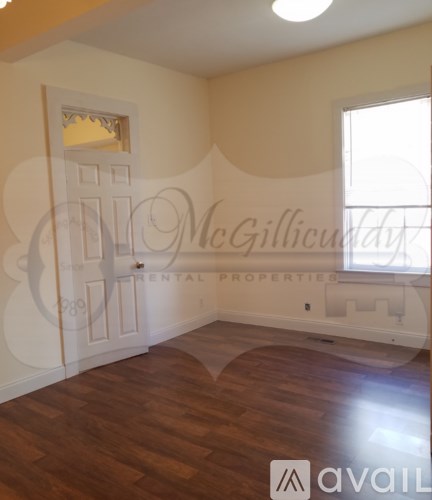 A room with wooden floors and a window is available for rent.