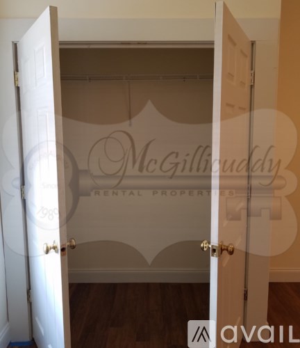 A white door is open to a room with a McGillicuddy Rental Properties sign.
