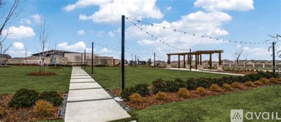 A walkway leads through a landscaped area with a building in the background.