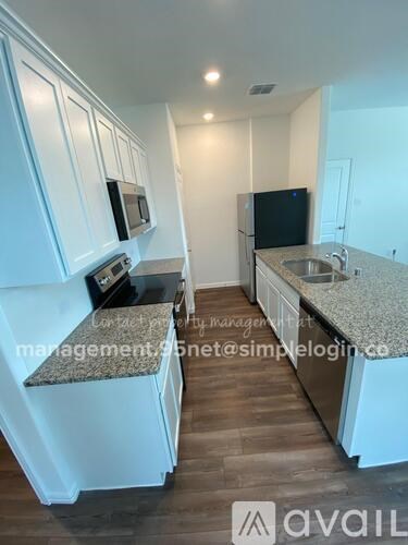 A kitchen with white cabinets and a granite countertop.