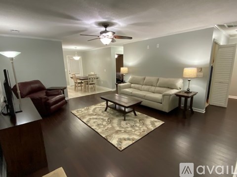 A living room with a brown leather chair and a white couch.