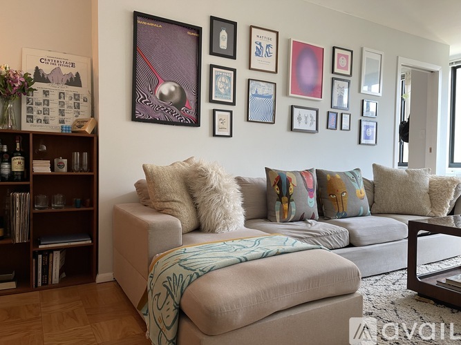 A living room with a grey couch and a bookshelf.