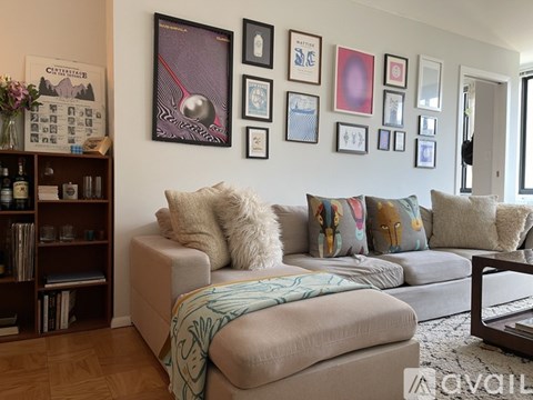 A living room with a grey couch and a bookshelf.