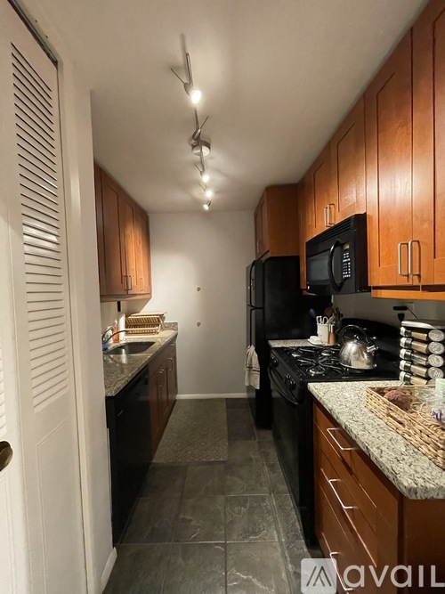 A kitchen with wooden cabinets and black appliances.