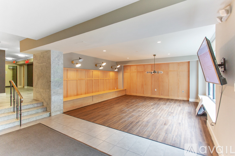 A spacious room with wooden floors and a television mounted on the wall.