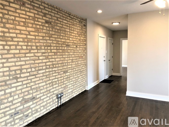 A room with a brick wall and wooden flooring.
