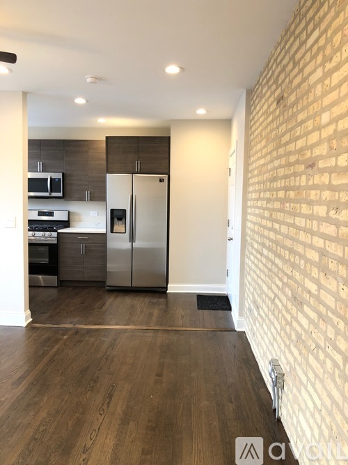 A kitchen with a refrigerator, microwave, and oven.