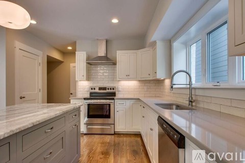 A modern kitchen with a stainless steel oven and white cabinets.
