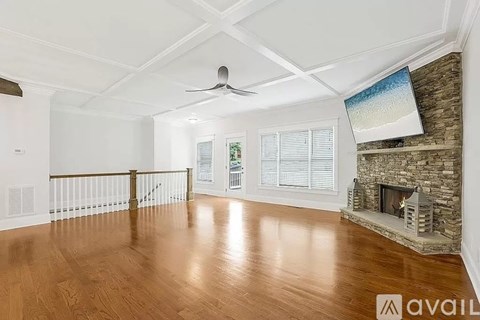 A living room with a fireplace and a television mounted above it.