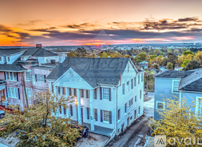 A sunset view of a residential area with houses and trees.