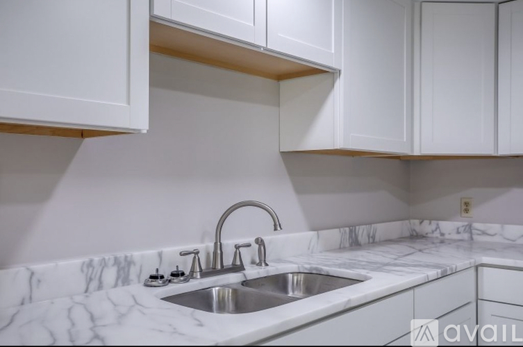 A kitchen with a marble countertop and white cabinets.