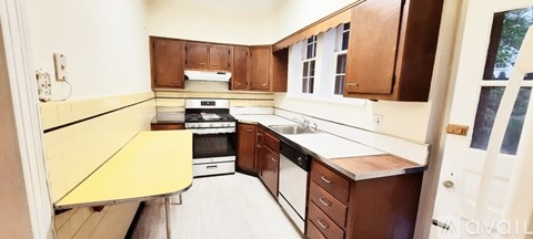 A kitchen with brown cabinets and a yellow counter.