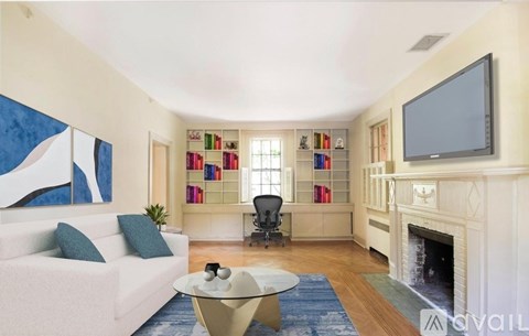 A living room with a white couch, a fireplace, and a television.