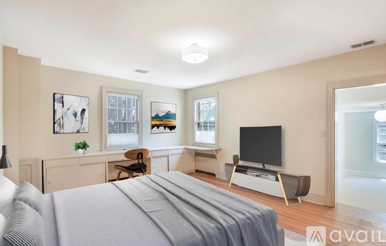 A bedroom with a large bed and a television in the corner.